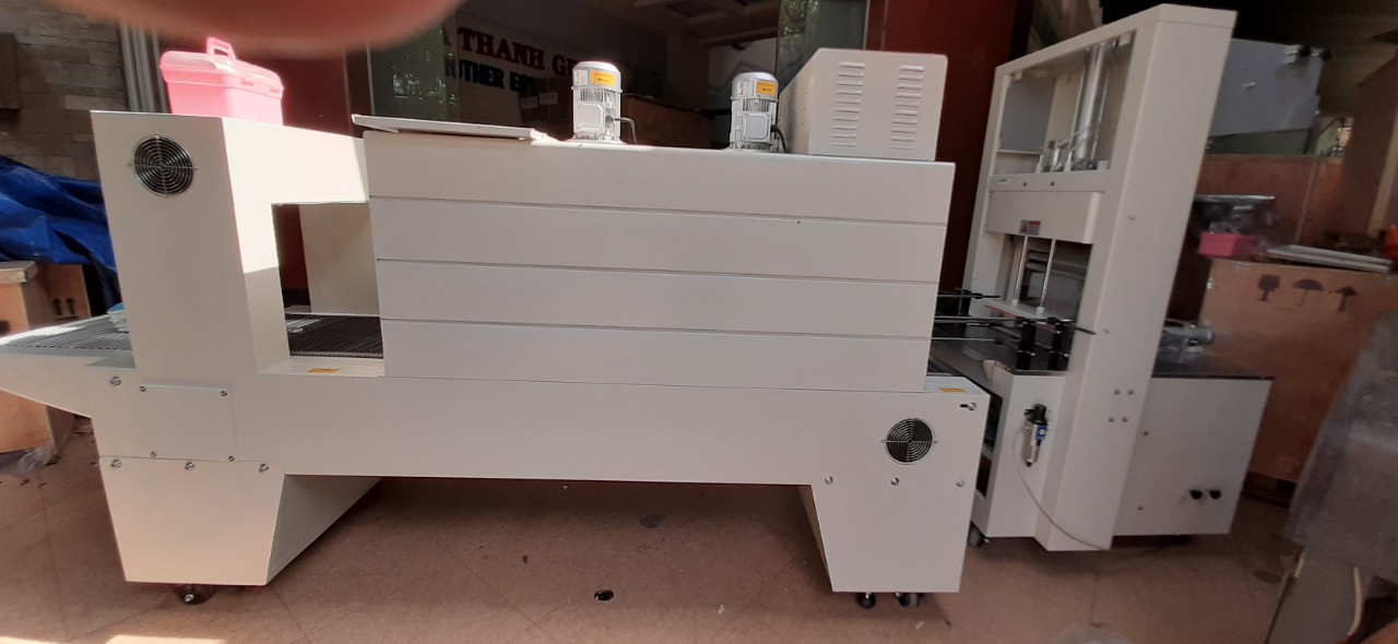 Máy cắt dán và rút màng co lốc chai- lon bán tự động, máy màng co lốc