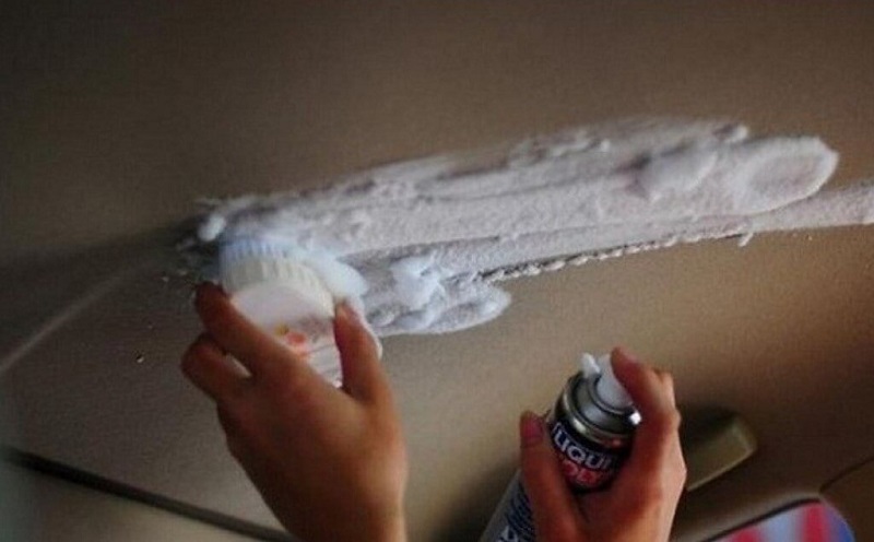 Xịt dung dịch vệ sinh lên trần xe