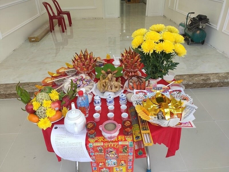 Mâm cúng về nhà mới bao gồm ngũ quả hương hoa và thức ăn